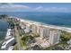 Wide aerial view shows the beautiful beach front condos with tennis courts, parking, and mature landscaping at 1180 Gulf Blvd # 504, Clearwater Beach, FL 33767