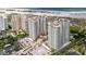 Stunning aerial view of beachfront condo buildings, lush landscaping, and beach access at 1180 Gulf Blvd # 504, Clearwater Beach, FL 33767