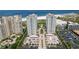 Aerial view showcasing beachfront condos, convenient parking, pool, and landscaped greenery near beach at 1180 Gulf Blvd # 504, Clearwater Beach, FL 33767