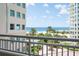 Beautiful condo balcony view overlooking the ocean, a sparkling pool, tropical trees, and white sand beach at 1180 Gulf Blvd # 504, Clearwater Beach, FL 33767