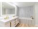 Bright bathroom with marble-look walls, double sinks, and a luxurious soaking tub at 1180 Gulf Blvd # 504, Clearwater Beach, FL 33767