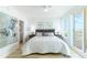 Light bedroom featuring balcony access, minimalist decor, and an ensuite bathroom at 1180 Gulf Blvd # 504, Clearwater Beach, FL 33767