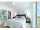 Bright bedroom with light walls, ceiling fan, and balcony access with ocean view at 1180 Gulf Blvd # 504, Clearwater Beach, FL 33767