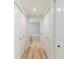 Hallway leading to the bathroom featuring closet doors and wood-look floors at 1180 Gulf Blvd # 504, Clearwater Beach, FL 33767