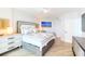 Light, bright main bedroom with a luxury bed, bedside tables, and beach artwork at 1180 Gulf Blvd # 504, Clearwater Beach, FL 33767