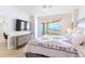 Main bedroom with balcony access features a decorative dresser, TV, and views at 1180 Gulf Blvd # 504, Clearwater Beach, FL 33767