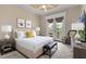 This bedroom features a queen bed, neutral walls, and a private door to a balcony to let fresh air in at 12125 Stonelake Ranch Blvd, Thonotosassa, FL 33592