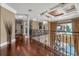 Spacious hallway with hardwood floors, iron railing, and pool view at 12125 Stonelake Ranch Blvd, Thonotosassa, FL 33592