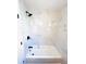 Updated bathroom with marble-tiled walls, a shower head, and a bright white bathtub at 1300 21St S St, St Petersburg, FL 33712