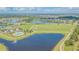 Expansive aerial shot of a community's pool, tennis courts and green space, all nestled among serene lakes at 13527 Willow Bluestar Loop, Riverview, FL 33579