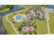 Aerial view of community amenities featuring a pool, playground, and lush landscaping by the lake at 13527 Willow Bluestar Loop, Riverview, FL 33579