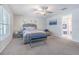 Bright bedroom with modern furnishings, plush carpet, a ceiling fan, and natural light from the windows at 13527 Willow Bluestar Loop, Riverview, FL 33579