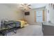 Comfortable bedroom featuring neutral walls, plush carpet, ceiling fan, and stylish yellow accents at 13527 Willow Bluestar Loop, Riverview, FL 33579