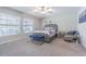 Bright bedroom with modern furnishings, plush carpet, a ceiling fan, and natural light from the windows at 13527 Willow Bluestar Loop, Riverview, FL 33579