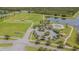 Aerial view of community amenities: pool, tennis courts, and open green space with lush landscaping near a pond at 13527 Willow Bluestar Loop, Riverview, FL 33579