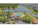 Aerial view of a sparkling community pool and clubhouse surrounded by well-manicured landscaping and a scenic pond at 13527 Willow Bluestar Loop, Riverview, FL 33579