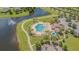 Overhead view of a community pool with hot tub, sun loungers, palm trees and manicured landscape near a pond at 13527 Willow Bluestar Loop, Riverview, FL 33579