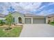 Inviting home exterior featuring a two-car garage, lush landscaping, and a welcoming front entrance at 13527 Willow Bluestar Loop, Riverview, FL 33579