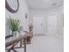 Bright entryway with tile flooring, featuring a decorative table, bench, and a view of the front door at 13527 Willow Bluestar Loop, Riverview, FL 33579