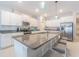 Stylish kitchen island features granite countertops, bar stool seating, and modern pendant lighting at 13527 Willow Bluestar Loop, Riverview, FL 33579