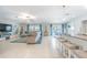 Spacious living room with bar seating, modern lighting, and comfortable sectional sofa at 13527 Willow Bluestar Loop, Riverview, FL 33579