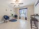 Cozy living room boasting stylish blue accents, a ceiling fan, and natural light from the window at 13527 Willow Bluestar Loop, Riverview, FL 33579