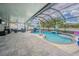Screened-in pool area with ample seating, featuring a waterfall feature and a tranquil atmosphere at 13527 Willow Bluestar Loop, Riverview, FL 33579
