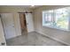 Comfortable bedroom with tile flooring, a sliding barn door to the bathroom, and lots of natural light at 1407 Coral Ridge Dr, Punta Gorda, FL 33950