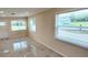 Bright living room featuring sleek, light-colored tile flooring, and views to the outside from the windows at 1407 Coral Ridge Dr, Punta Gorda, FL 33950