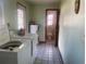 Laundry room with washing machine and dryer adjacent to bathroom, offering convenience and functionality at 1480 Fairfield Dr, Clearwater, FL 33764