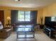 Inviting living room with a plush sofa, a glass coffee table, and natural light filtering through the window at 1480 Fairfield Dr, Clearwater, FL 33764