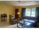 Cozy living room featuring comfortable seating, warm lighting, and a large window overlooking the yard at 1480 Fairfield Dr, Clearwater, FL 33764