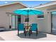 Cozy back porch area with outdoor seating, an umbrella, and sliding glass doors for easy access at 1675 E Grovehill Rd, Palm Harbor, FL 34683