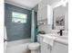 Modern bathroom featuring blue tile shower, updated vanity, and stylish fixtures at 1675 E Grovehill Rd, Palm Harbor, FL 34683