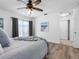 Bedroom with a cozy bed, ceiling fan, and sliding glass doors at 1675 E Grovehill Rd, Palm Harbor, FL 34683