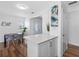 Open dining area with a modern table, seating, and an accent art piece, adjacent to the kitchen at 1675 E Grovehill Rd, Palm Harbor, FL 34683