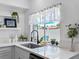 Stylish kitchen sink with modern fixtures, quartz countertops, and a view of the backyard at 1675 E Grovehill Rd, Palm Harbor, FL 34683