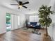 Comfortable living room with a blue sofa, natural light, and a view of the outdoor deck and backyard at 1675 E Grovehill Rd, Palm Harbor, FL 34683