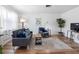 Modern living room with wood floors, gray sofa, armchair and bright natural light at 1675 E Grovehill Rd, Palm Harbor, FL 34683