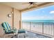 Enjoy the breathtaking ocean views from the outdoor balcony with tile flooring, chair, and a column at 17720 Gulf Blvd # A702, Redington Shores, FL 33708