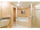 Luxurious bathroom featuring a walk-in shower, soaking tub, tile flooring, and granite countertops at 17720 Gulf Blvd # A702, Redington Shores, FL 33708