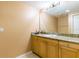 Clean bathroom featuring a sink with granite countertops, a large mirror, and wooden cabinets at 17720 Gulf Blvd # A702, Redington Shores, FL 33708