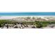Beach view from an upper deck with patio furniture, umbrellas, and a barbecue at 17720 Gulf Blvd # A702, Redington Shores, FL 33708
