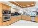 Bright kitchen boasts wooden cabinetry, granite countertops, stainless steel appliances, and a view into the dining and living rooms at 17720 Gulf Blvd # A702, Redington Shores, FL 33708