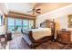 Bedroom with a large bed, elegant furnishings, and balcony access with ocean views at 17720 Gulf Blvd # A702, Redington Shores, FL 33708