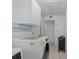 Bright laundry room features upper storage cabinets, a mural, and a modern washer and dryer at 1811 49Th N St, St Petersburg, FL 33710