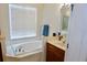 Bright bathroom featuring a large soaking tub, vanity with marble countertop, and tiled floors at 18439 Red Willow Way, Land O Lakes, FL 34638