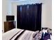 Spacious bedroom featuring a dresser, TV, and black-out curtains providing privacy and darkness at 18439 Red Willow Way, Land O Lakes, FL 34638