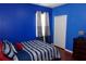 Bedroom with a blue wall, bed, curtains, and closet at 18439 Red Willow Way, Land O Lakes, FL 34638