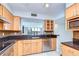 Well-lit kitchen featuring wooden cabinetry, stainless steel appliances, and a breakfast bar opening to the living area at 2413 Bayshore Blvd # 1903, Tampa, FL 33629